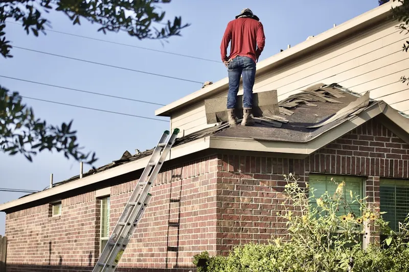 Professional roofer working on a residential roof in Raceway Farms